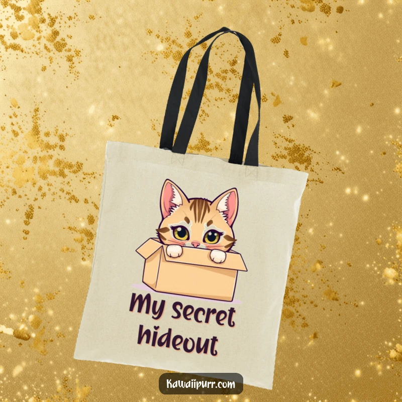 Funny tote bag with a mischievous tabby cat hiding inside a cardboard box, peeking out with bright eyes.